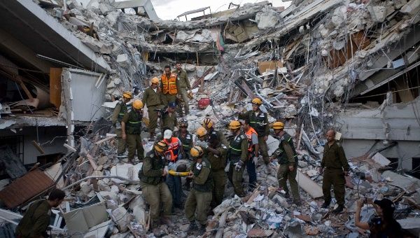  Imagen del 16 de enero de 2010 de bomberos israelíes rescatando a una persona herida de entre los escombros de un edificio derruido luego de un terremoto en Puerto Príncipe, capital de Haití.