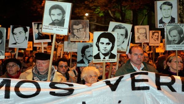 Miles de uruguayos se concentran silenciosamente cada año en la Avenida Principal de Montevideo con las fotos de los desaparecidos en la dictadura.