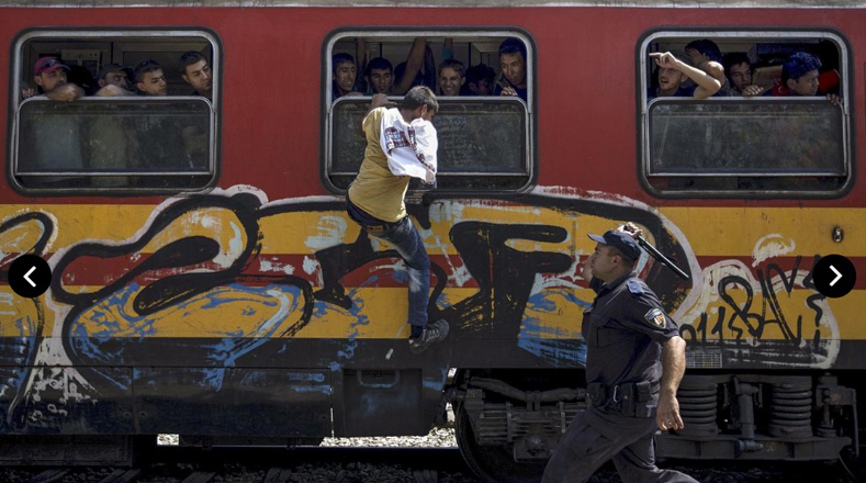 Un policía intenta frenar a un refugiado en un tren en Macedonia.