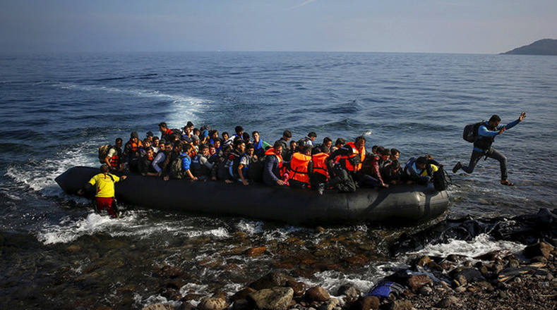 Un inmigrante afgano salta de una balsa en una playa en la isla griega de Lesbos.