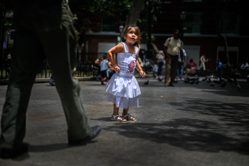 Una niña juega cerca del monumento del Libertador Simón Bolívar en la plaza que lleva su nombre.