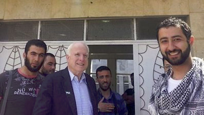 John McCain durante su estancia ilegal en territorio sirio. En primer plano a la derecha aparece el director de la Syrian Emergency Task Force. Al centro de la imagen, parado en la puerta, aparece Mohammad Nur.(Foto: Voltairenet)