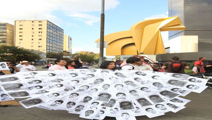 Una de las manifestantes usó un vestido con fotos de los 43 desaparecidos. EFE