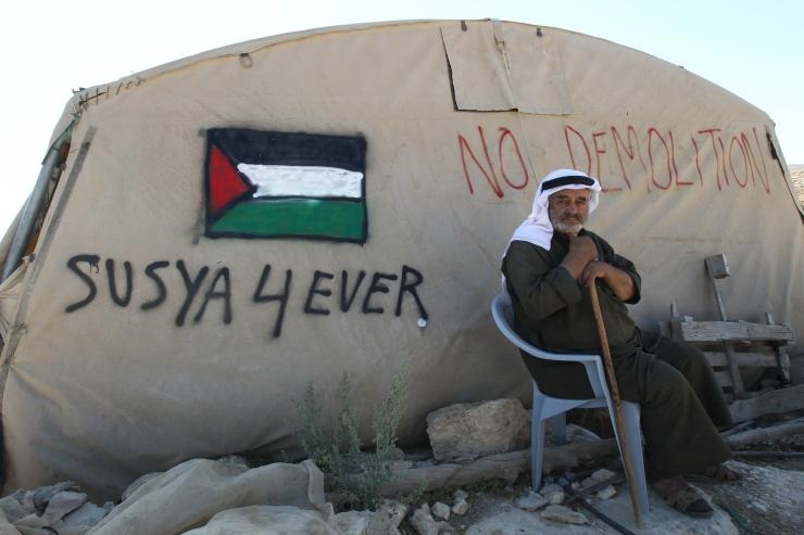 Un palestino se sienta frente a su tienda de campaña en la aldea de Susiya, el 22 de julio de 2015. Israel quiere demoler el pueblo y desplazar a la fuerza a más de 300 palestinos.