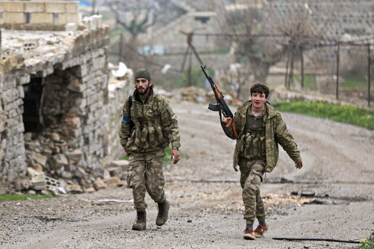 Combatientes antigunermanetales del Ejército Libre Sirio, respaldados por Turquía, caminan por las calles de Afrín.