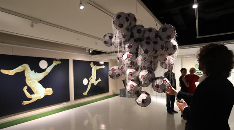 El balón de fútbol en sus diversas presentaciones es parte de la muestra artística, la cual refleja las jugadas más icónicas realizadas por los deportistas en el campo.