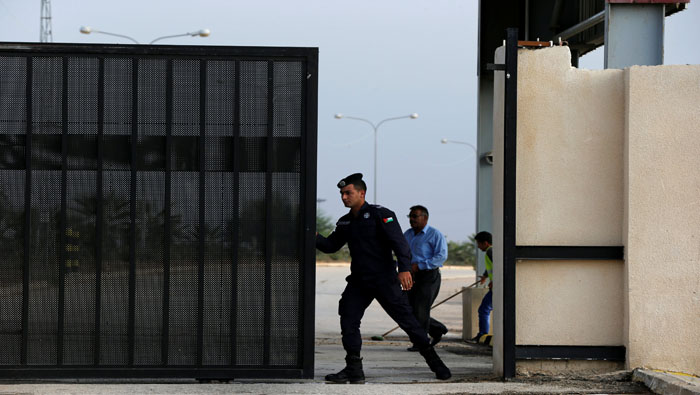 Un policía jordano abre el portón del puesto de control que da acceso al cruce fronterizo de Nassib-Yaber.