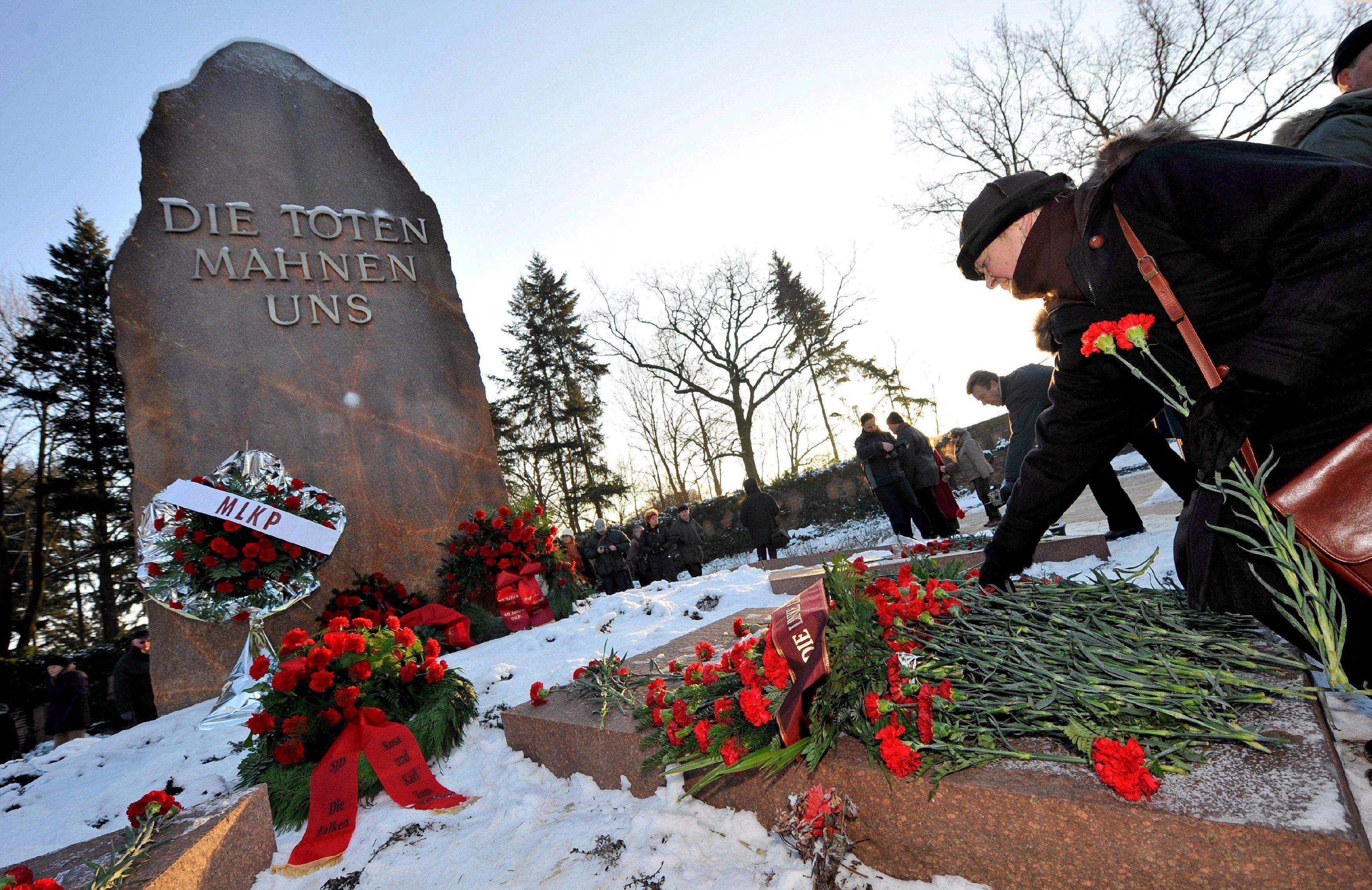Un grupo de personas asistieron al cementerio de Berlín con coronas de crisantemos y claveles rojos, en vísperas del centenario del asesinato de Rosa Luxemburgo.