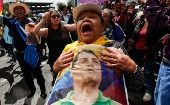 Una mujer sostiene una foto del el expresidente Rafael Correa durante un acto politico en Quito, Ecuador, 18 de junio de 2018.