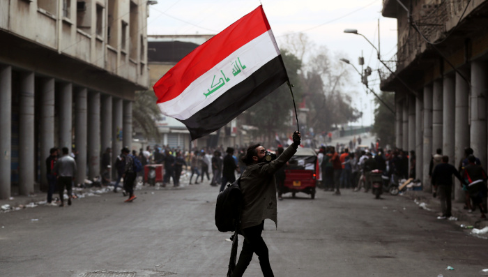 Un manifestante lleva una bandera iraquí durante las continuas protestas antigubernamentales en Bagdad.