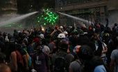 Manifestantes enfrentan a un carro lanza-agua de Carabineros en una protesta en Santiago de Chile.