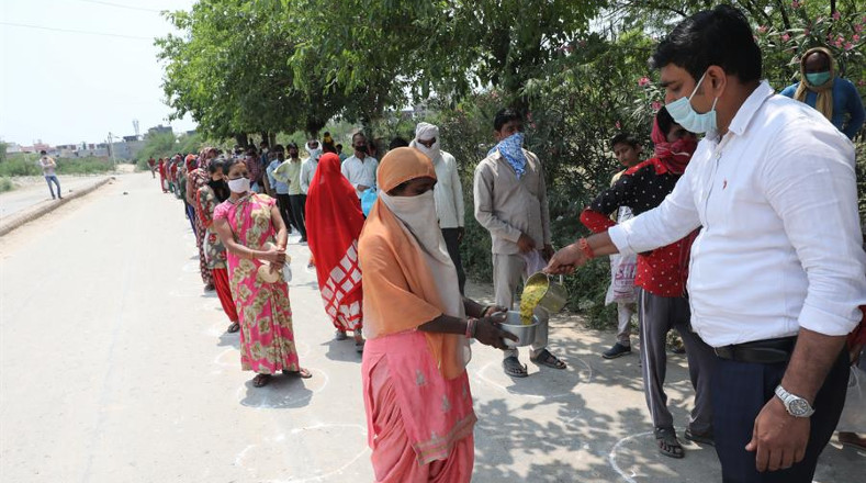 El aislamiento social es, al decir de expertos, la única vacuna hasta la fecha. En la foto, personas en la India hacen fila para recibir alimentos, con la distancia establecida por las autoridades.