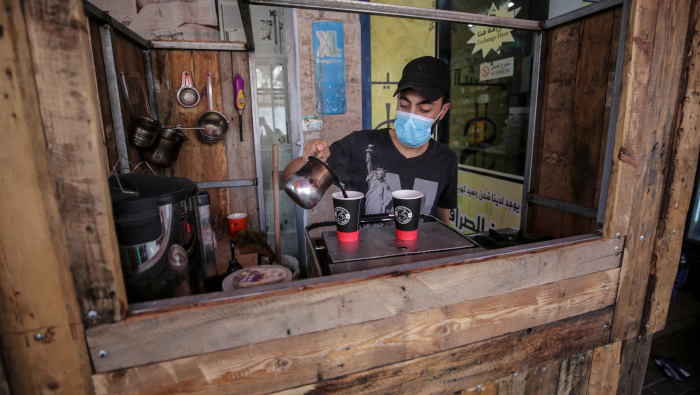 Un palestino con una mascarilla vende café y té en medio de la pandemia de Covid-19 en la ciudad de Gaza.