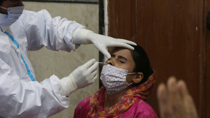 Un paramédico toma una muestra de un comerciante de Cachemira para realizar su prueba rápida de antígeno para la Covid-19.