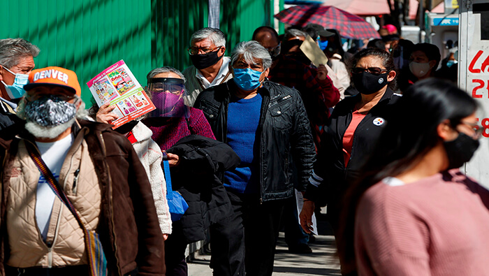 Mexicanos esperan su turno para aplicarse la vacuna contra el coronavirus.