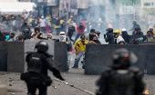 Miembros de la primera línea hacen frente a efectivos policiales durante una manifestación en la capital colombiana.