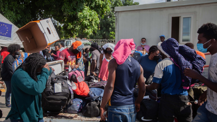 Migrantes haitianos deportados desde Estados Unidos recogen sus pertenencias en un aeropuerto, en Puerto Príncipe, Haití, el 19 de septiembre de 2021.