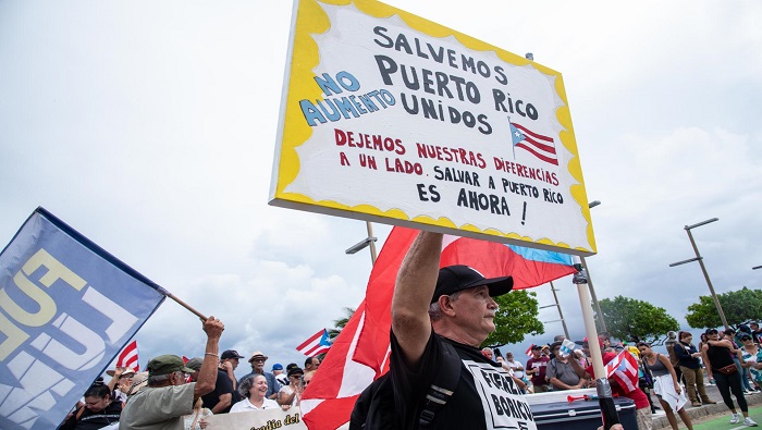 La marcha enfiló en dirección a la mansión del gobernador, en cuyas afueras izaron banderas puertorriqueñas y enarbolaron letreros.